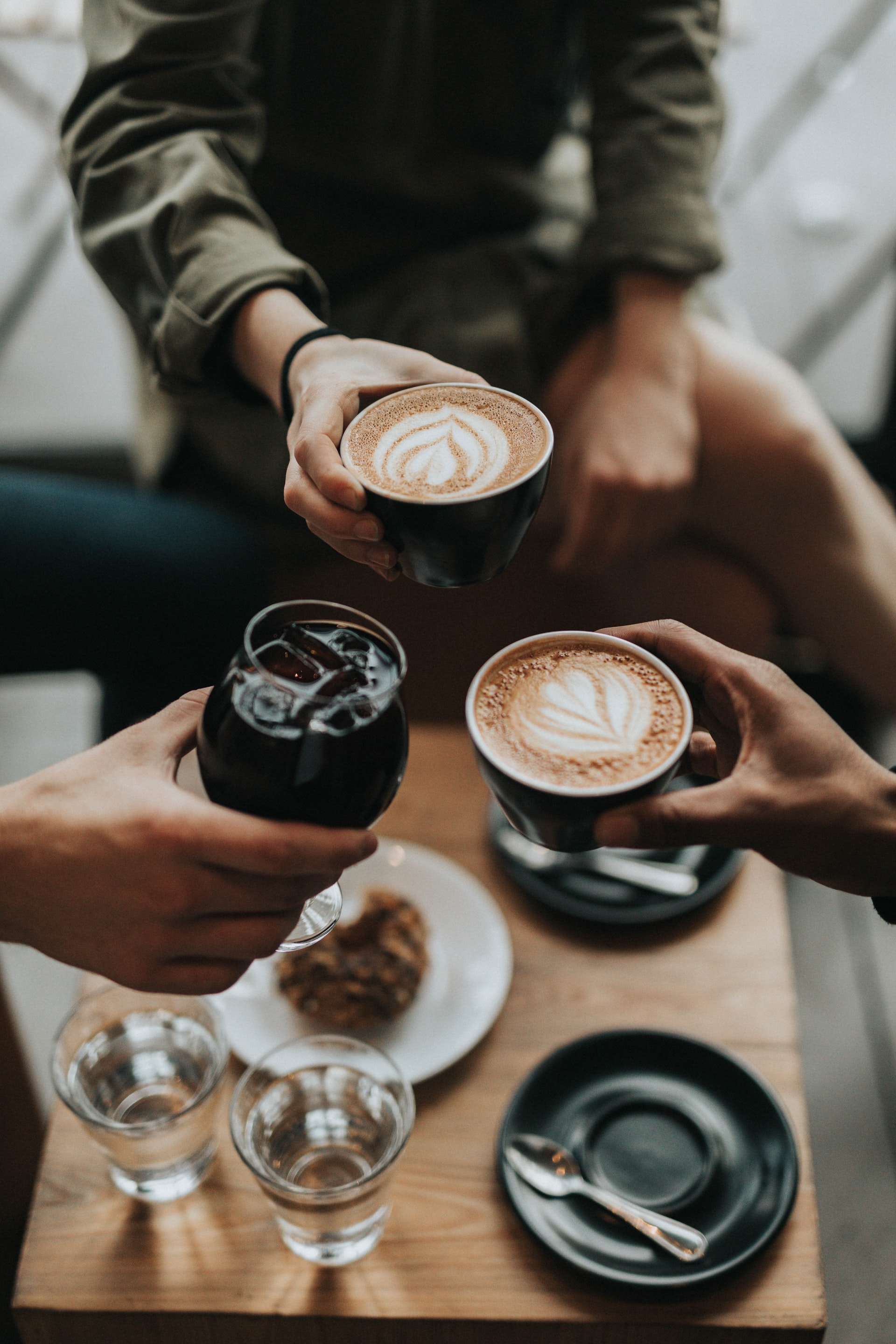 three person holding mug with beverage inside